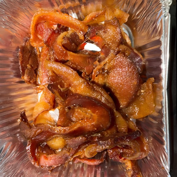 Crispy, candied bacon strips in a foil container from Finn's Deli.