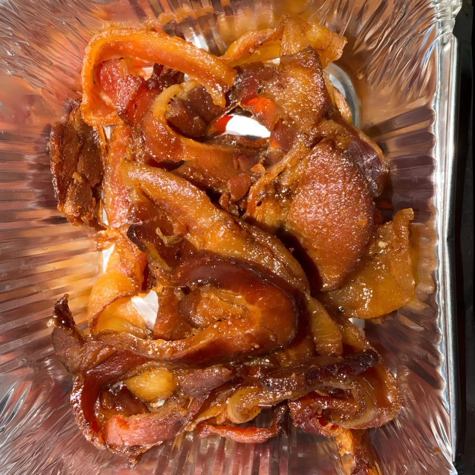 Crispy, candied bacon strips in a foil container from Finn's Deli.